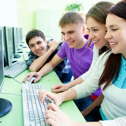 group of young students studying in the classroom with computer