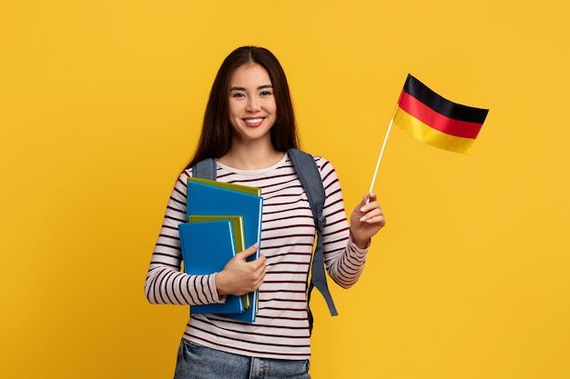 Premium Photo _ Happy young asian woman student showing flag of germany